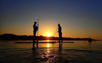 Paddleboarders at sunset on Ishigaki Island, Okinawa.