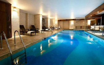 Indoor pool area at Istanbul Turkish Bath with lounge chairs and ambient lighting.