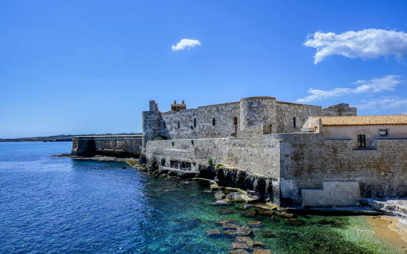 Ortigia waterfront with historic stone fortress, Siracusa, Italy.