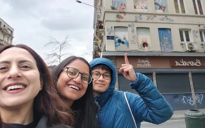Visitors exploring comic murals on a building in Brussels during a self-guided city game.
