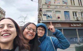 Visitors exploring comic murals on a building in Brussels during a self-guided city game.