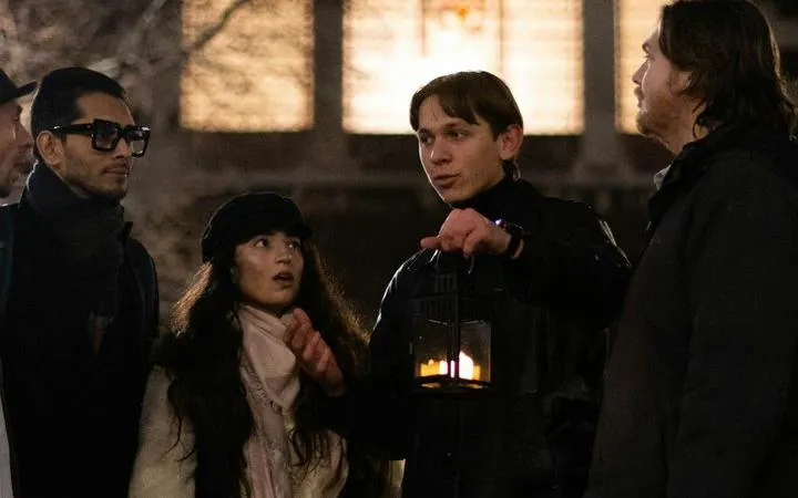 Group on Jack the Ripper walking tour in London, guide holding lantern.