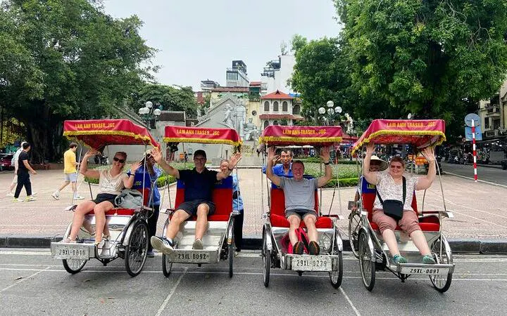 Tourists on cyclos in Hanoi's Old Quarter near Train Street.