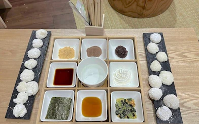 Mochi rice cakes with various toppings and sauces for tasting experience.
