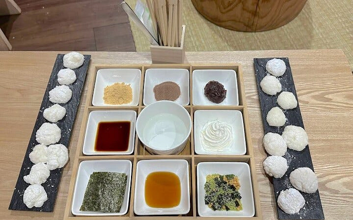 Mochi rice cakes with various toppings and sauces for tasting experience.