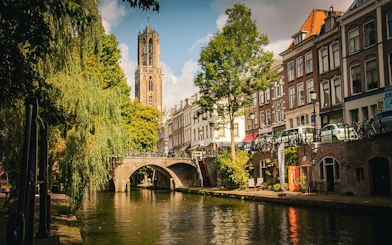 Utrecht canal view with Dom Tower and historic buildings on walking tour route.