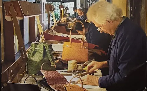 Artisan crafting leather bags in Florence workshop during guided tour.
