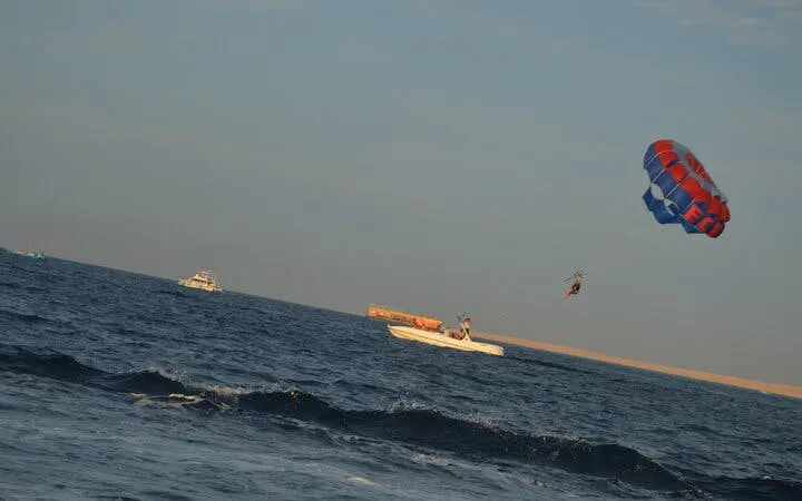 Parasailing over the sea with a glass boat in Sharm El Sheikh.