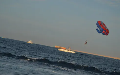 Parasailing over the sea with a glass boat in Sharm El Sheikh.