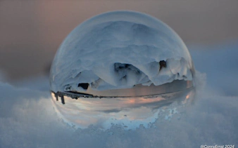 Reykjavik landscape reflected in a glass sphere on snow during a guided walking tour.