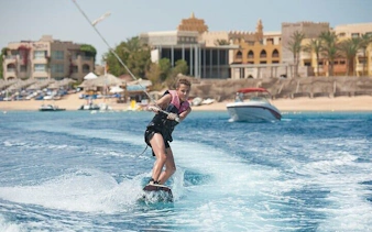 Water skiing near Sharm El Sheikh with view of beach and glass-bottom boat.