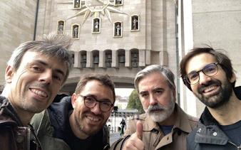 Old Town Brussels clock tower with four smiling tourists on a self-guided beer exploration game.