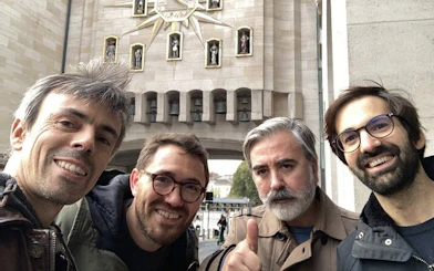Old Town Brussels clock tower with four smiling tourists on a self-guided beer exploration game.