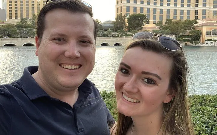 Couple smiling in front of Bellagio fountains on Las Vegas Strip.