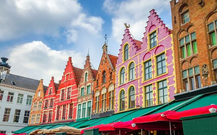 Colorful gabled houses in Bruges, Belgium, part of a self-guided city exploration game.