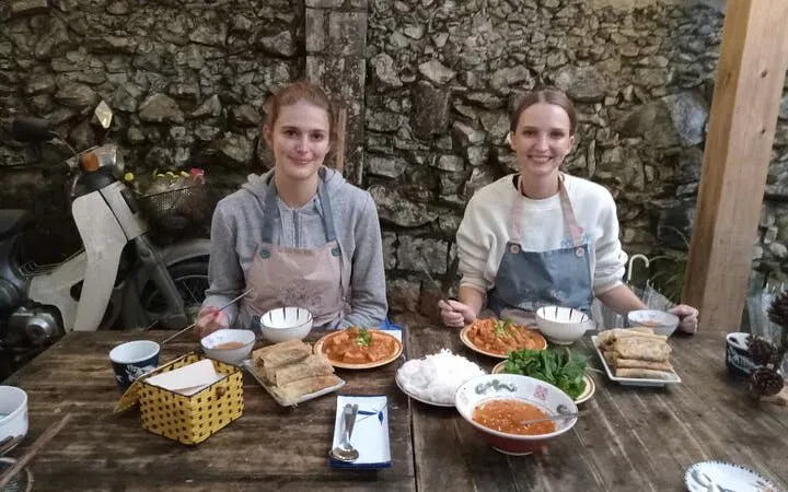 Two people enjoying a Pho noodle soup meal at a cooking class with a local chef.