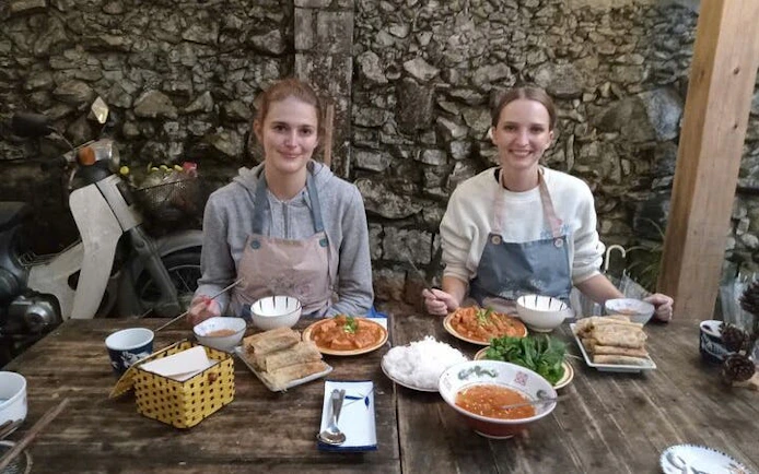 Two people enjoying a Pho noodle soup meal at a cooking class with a local chef.