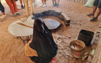 Local woman preparing traditional bread during desert safari in Sharm El Sheikh.