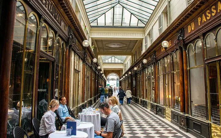 Parisian covered passageway with people dining and walking, part of a 2-hour walking tour.