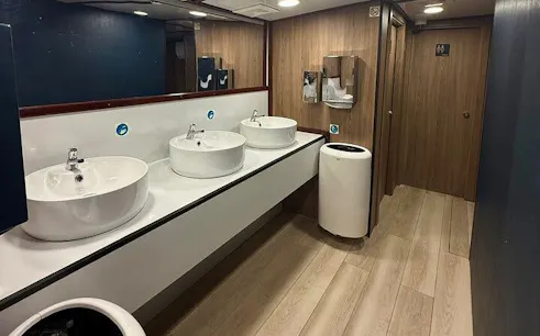 Restroom facilities on Malta boat cruise with modern sinks and wooden decor.