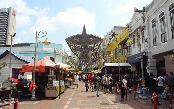 Petaling Street market in Kuala Lumpur with stalls and visitors.