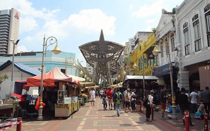 Petaling Street market in Kuala Lumpur with stalls and visitors.