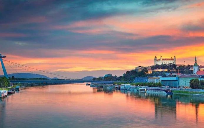 Bratislava Castle and Danube River at sunset during self-guided walking tour.