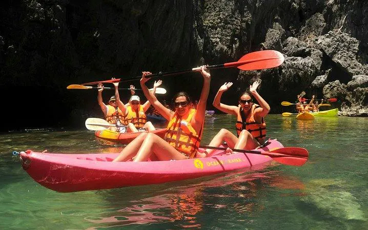 Kayakers in Ang Thong National Marine Park, Koh Samui, paddling near rocky cliffs.