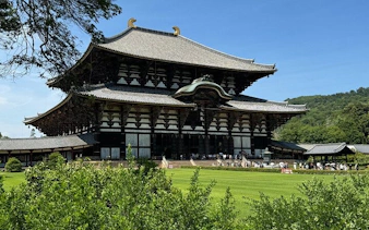 Todai-ji Temple in Nara with surrounding greenery on a sunny day.