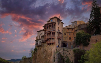 Hanging Houses of Cuenca at sunset, part of self-guided walking tour on mobile app.