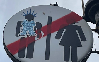 Punk-themed restroom sign in Reykjavik with graffiti elements.
