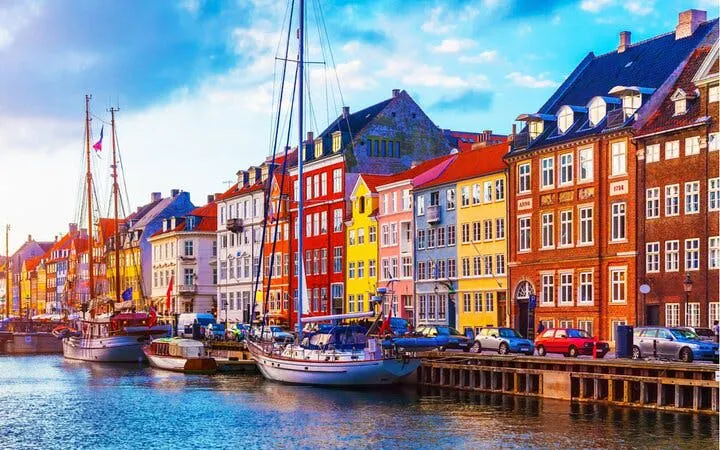 Colorful buildings along Nyhavn canal in Copenhagen with docked boats.