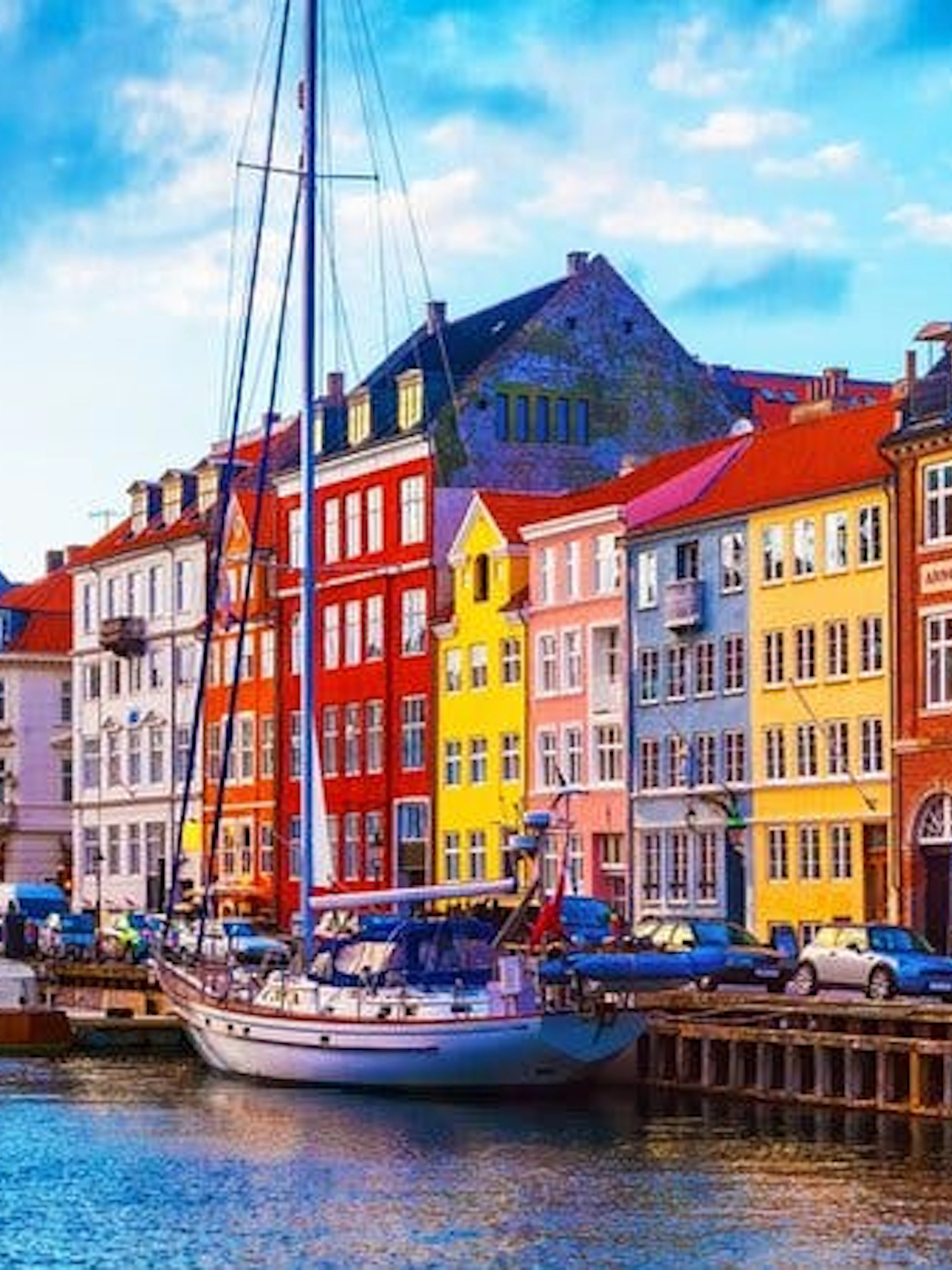 Colorful buildings along Nyhavn canal in Copenhagen with docked boats.