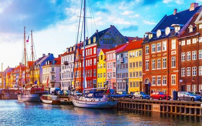 Colorful buildings along Nyhavn canal in Copenhagen with docked boats.