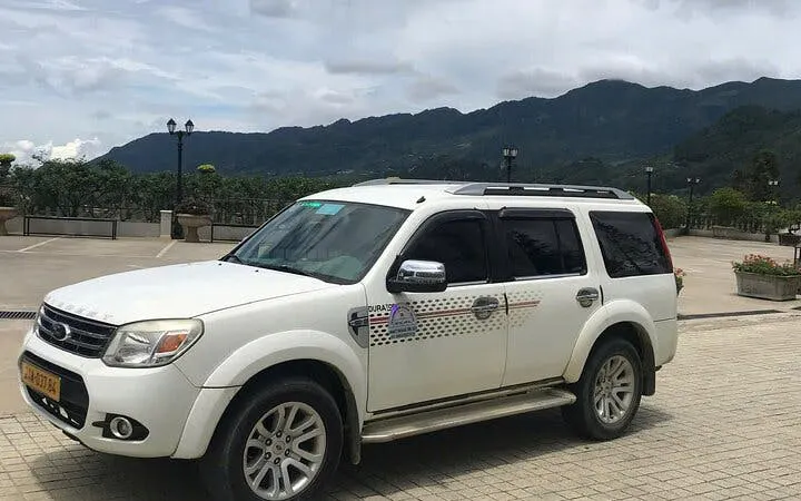 Private car for Sapa to Ha Giang City transfer with mountain view in background.