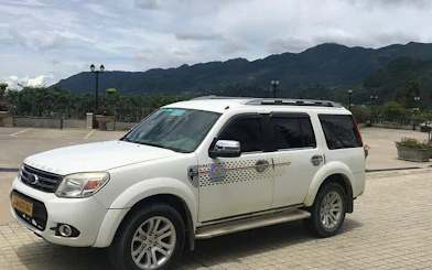 Private car for Sapa to Ha Giang City transfer with mountain view in background.