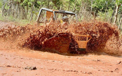 Buggy driving through muddy terrain in Punta Cana during adventure tour.