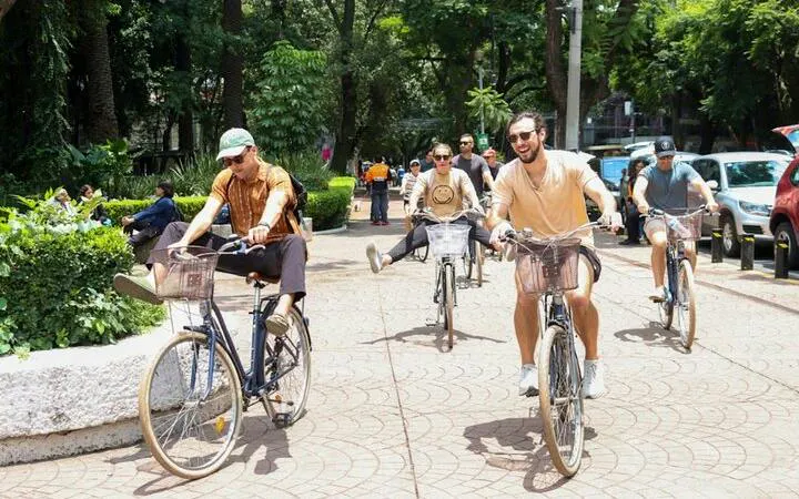 Cyclists enjoying a taco tour in Mexico City park.