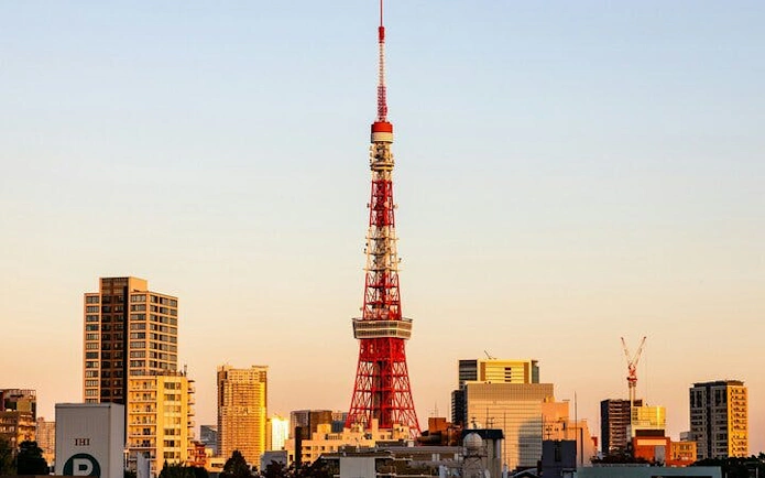 Tokyo Tower at sunset with city skyline in the background.