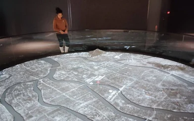 Hiroshima Peace Memorial Museum visitor observing city map exhibit.