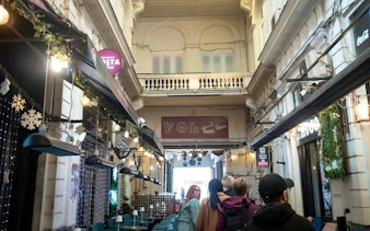 Walking tour group exploring a historic arcade in Bucharest Old Town.