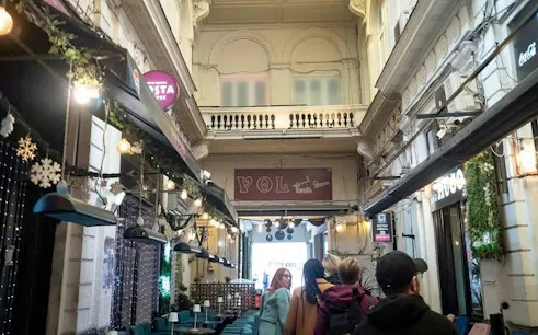 Walking tour group exploring a historic arcade in Bucharest Old Town.