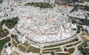 Aerial view of Locorotondo's circular old town with whitewashed buildings in Valle d'Itria, Italy.