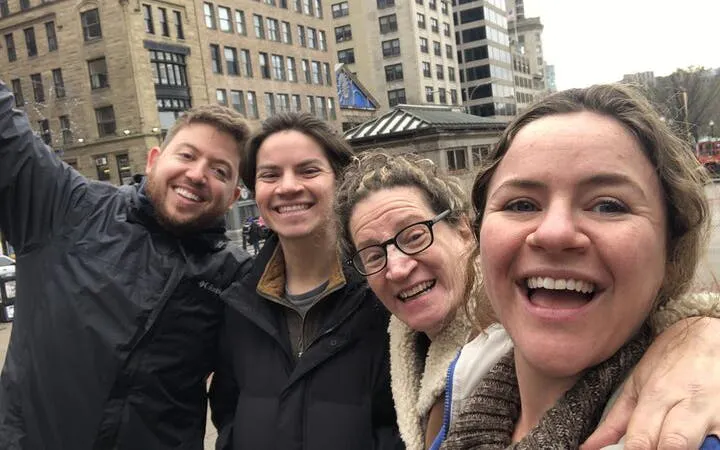 Group enjoying a self-guided exploration game in historical Boston with city buildings in the background.