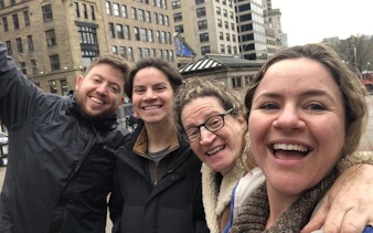 Group enjoying a self-guided exploration game in historical Boston with city buildings in the background.