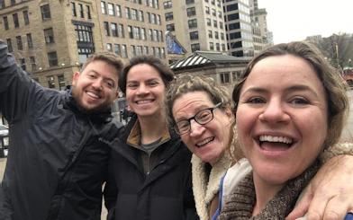 Group enjoying a self-guided exploration game in historical Boston with city buildings in the background.