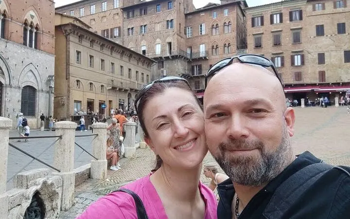 Piazza del Campo in Siena with tourists exploring the historic square.