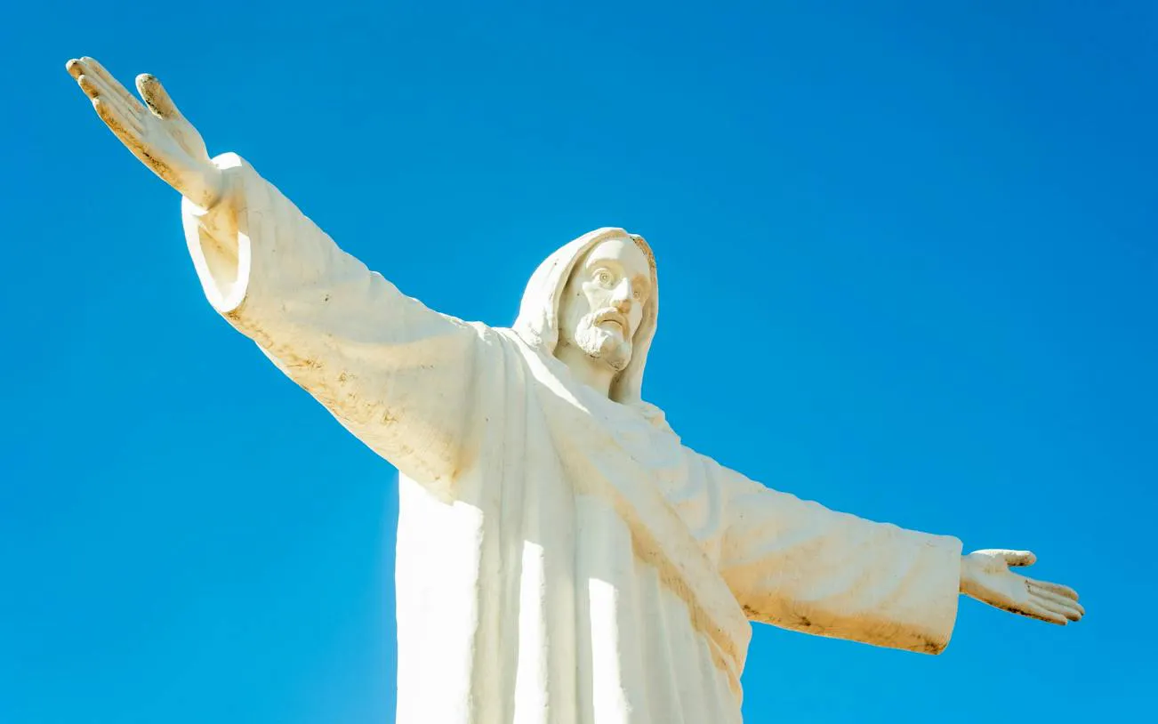 Cristo Blanco statue with outstretched arms against blue sky, Cusco, Peru.