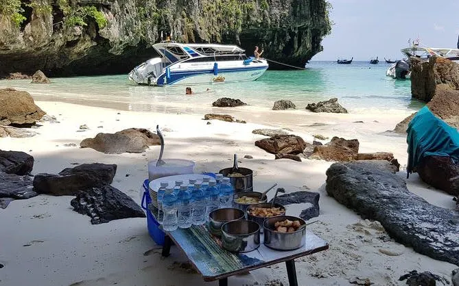 Speedboat anchored on Krabi beach with picnic setup for 4 Islands Sunset and Plankton tour.