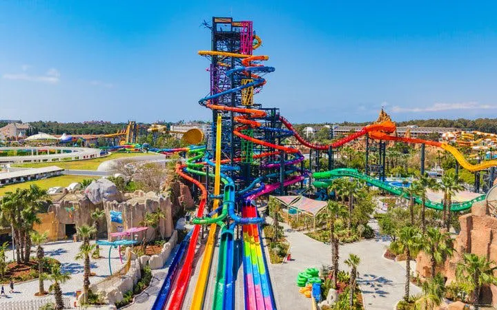 Colorful water slides at The Land of Legends Theme Park, Turkey, with lush surroundings.